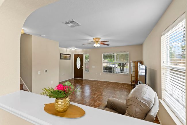 Living area with ceiling fan, arched walkways, and stairs | Image 14
