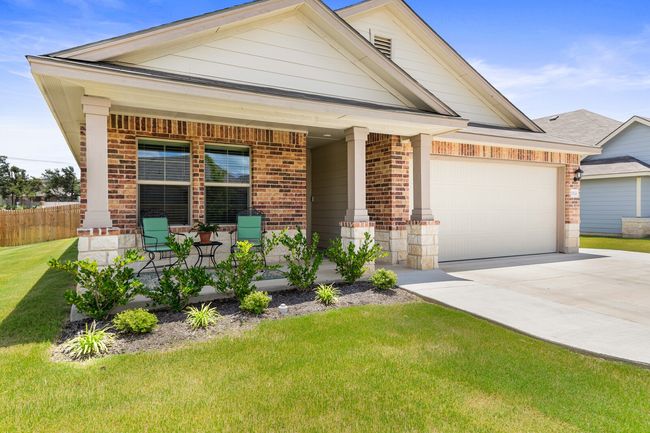 View of front of property with brick siding, covered porch, driveway, and a garage | Image 8