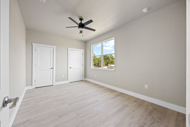 Unfurnished bedroom featuring multiple closets, light wood-style flooring, ceiling fan, and baseboards | Image 15