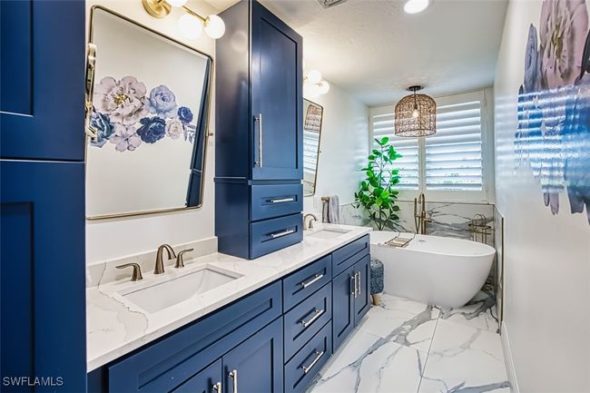 Full bath featuring marble look tiles, double vanity, and a freestanding bath | Image 31