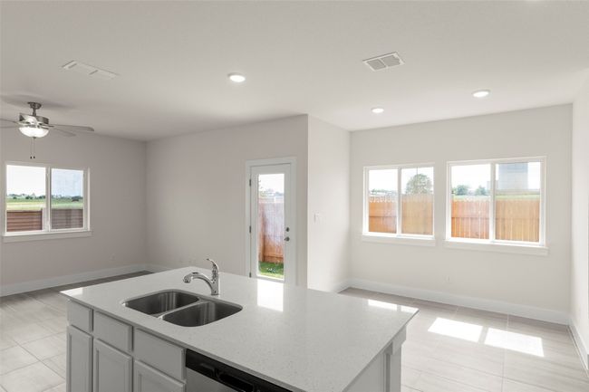 Kitchen with light tile patterned flooring, open floor plan, light stone countertops, and a sink | Image 15