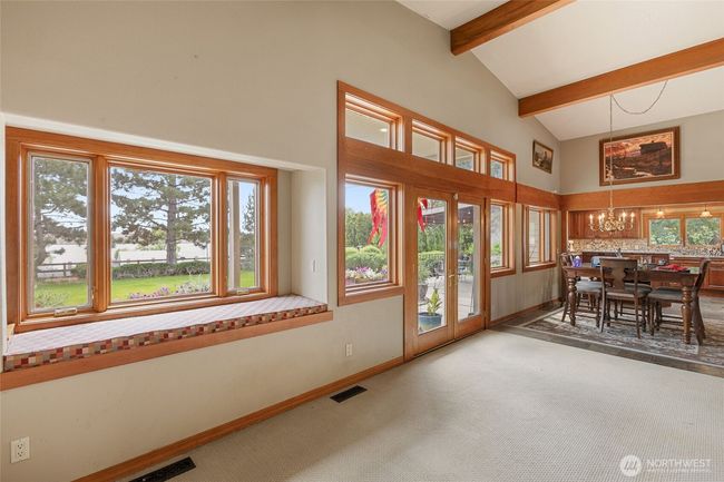 Great lake views and a room with window seat with storage. French doors lead to a spacious patio surrounded by beautiful flowers. | Image 14