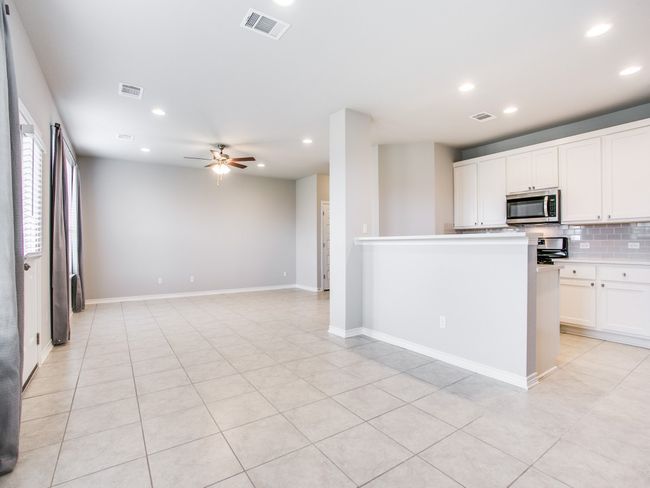 Kitchen featuring appliances with stainless steel finishes, recessed lighting, tasteful backsplash, white cabinets, and ceiling fan | Image 4