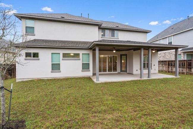 Rear view of property with a yard, stucco siding, fence, and a patio area | Image 37