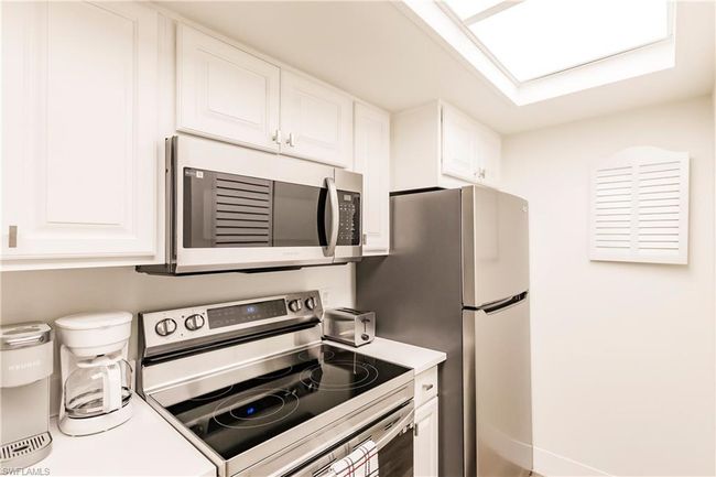 Kitchen with white cabinets, light countertops, and appliances with stainless steel finishes | Image 10