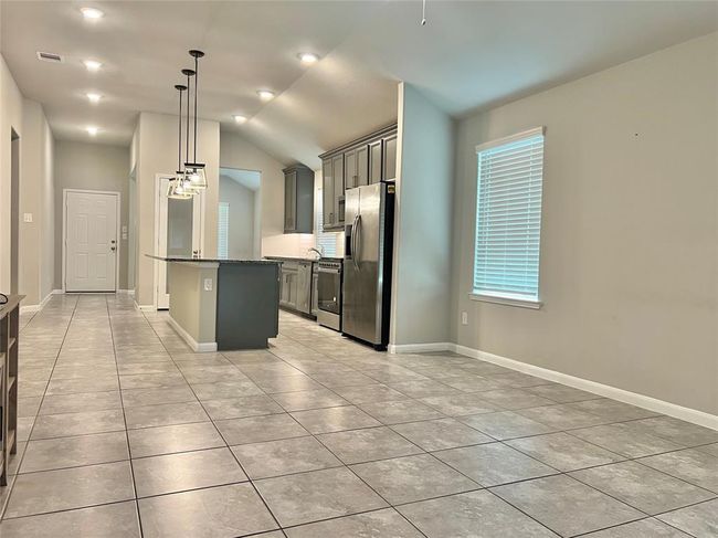 Experience the seamless flow from the spacious living room to the modern kitchen, beautifully illuminated with recessed lighting. | Image 9