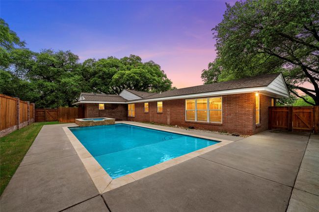 Pool at dusk featuring a gate, an in-ground hot tub, and a patio | Image 37