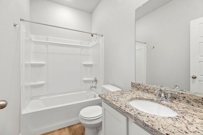 Bathroom featuring shower / washtub combination, vanity, toilet, and wood finished floors | Image 18