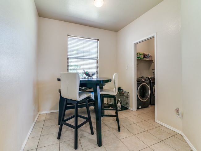 Dining space with washer and dryer, baseboards, and light tile patterned flooring | Image 12
