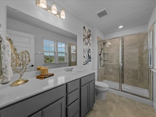 Bathroom featuring a shower stall, vanity, toilet, tile patterned flooring, and recessed lighting | Image 16