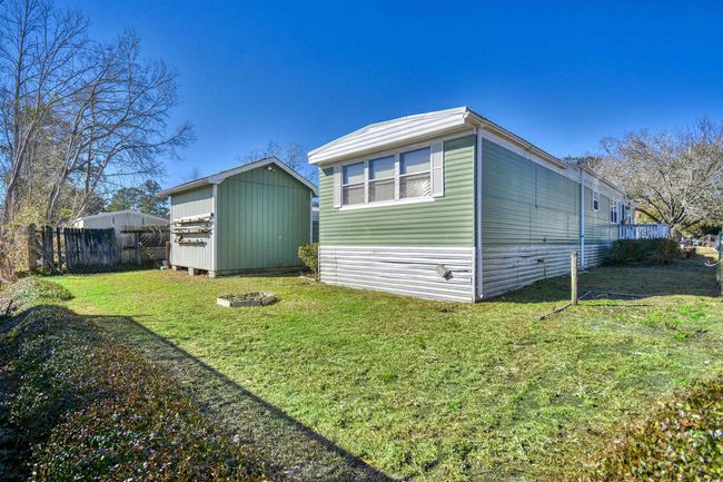 View of side of home with a storage shed and a yard | Image 25