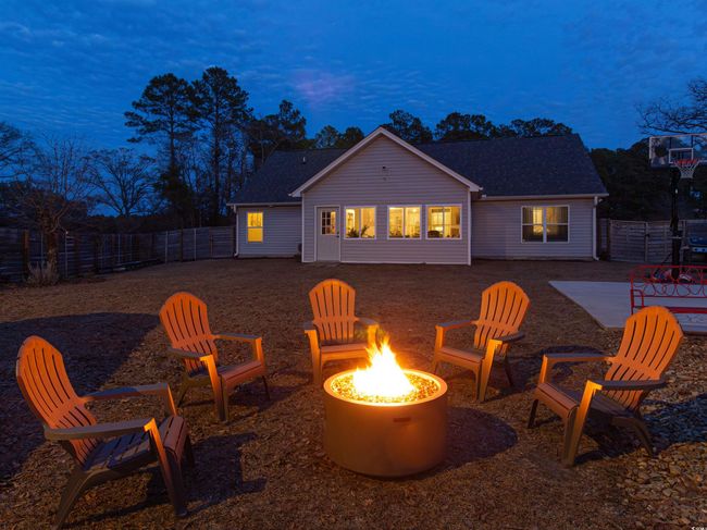 Back house at dusk featuring a patio area and an outdoor fire pit | Image 35