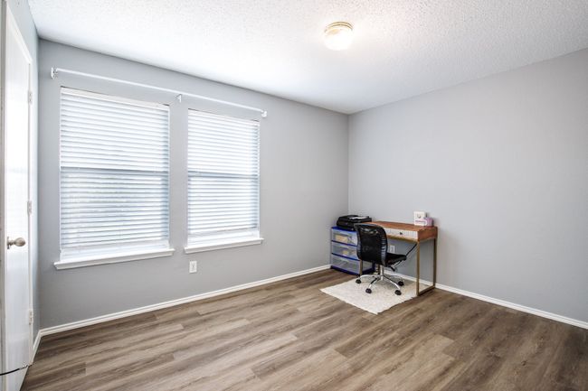 Unfurnished office featuring wood finished floors and a textured ceiling | Image 13