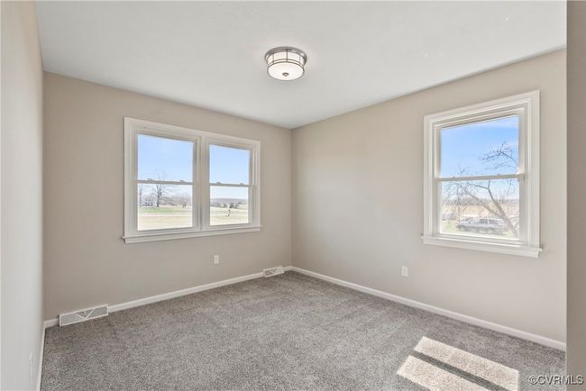 Carpeted spare room with baseboards, visible vents, and a healthy amount of sunlight | Image 22