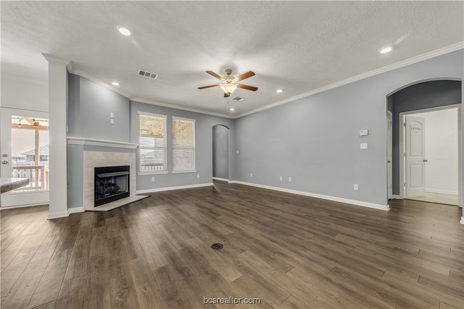 Unfurnished living room featuring ceiling fan, plenty of natural light, dark hardwood / wood-style floors, and a fireplace | Image 10