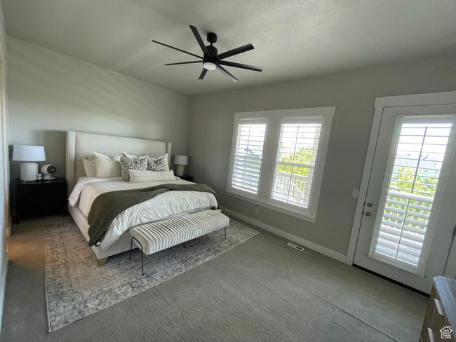 Carpeted master bedroom with a ceiling fan and multiple windows with fantastic views | Image 30