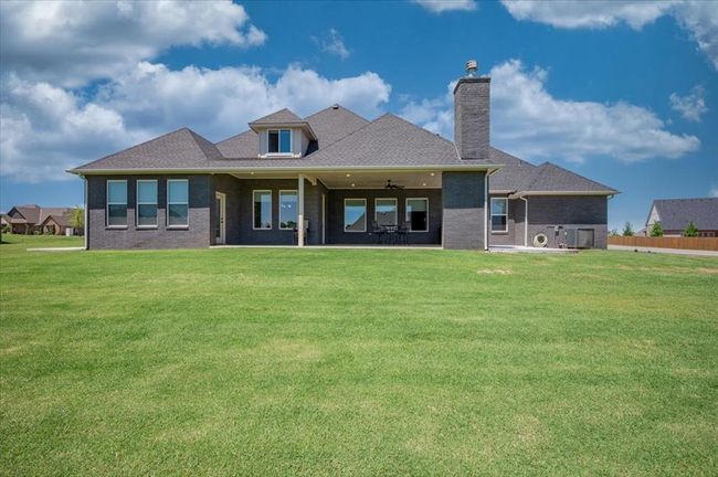 Back of property with a chimney, ceiling fan, brick siding, and roof with shingles | Image 5