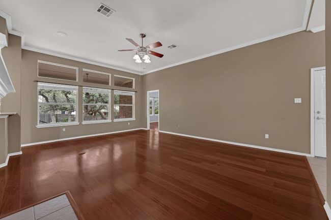Step inside to discover Brazilian hardwood floors, soaring ceilings with crown molding, and a cozy tile-hearth fireplace anchoring the spacious living area. | Image 5