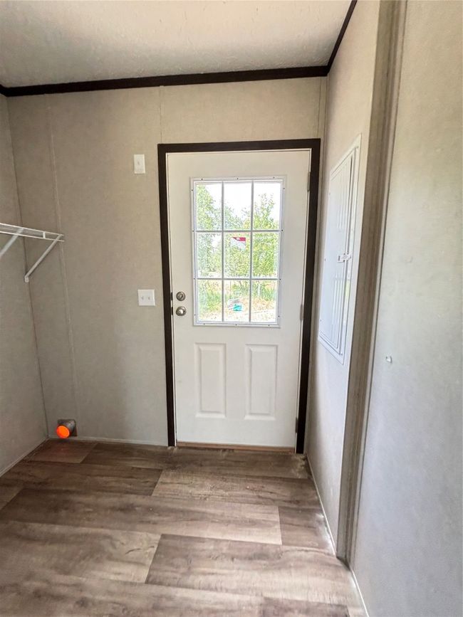 Doorway with wood finished look floors and ornamental molding | Image 21