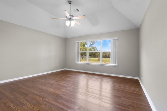 Spare room with lofted ceiling, wood finished floors, and a ceiling fan | Image 16