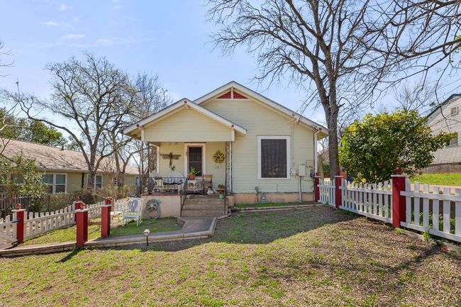 Bungalow-style house with a porch, a front lawn, and fence | Image 34