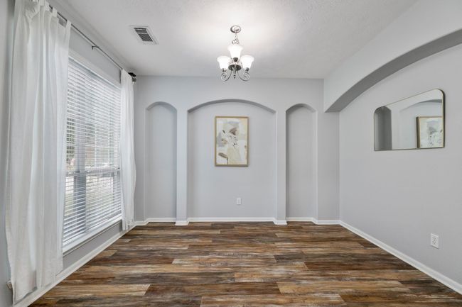 Recessed wall niches and a picture window add architectural interest to this light-filled front room. | Image 6
