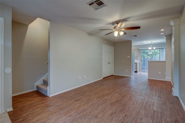 Unfurnished living room featuring a ceiling fan, wood finished floors, baseboards, and recessed lighting | Image 9