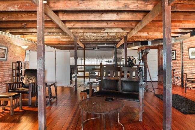 Basement with hardwood / wood-style floors and brick wall | Image 25