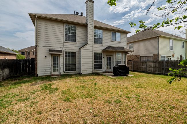 Rear view of house featuring a fenced backyard, a yard, and a chimney | Image 31