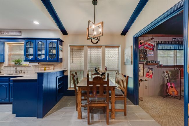 Dining space with healthy amount of natural light, a chandelier, light tile patterned floors, recessed lighting, and light carpet | Image 14