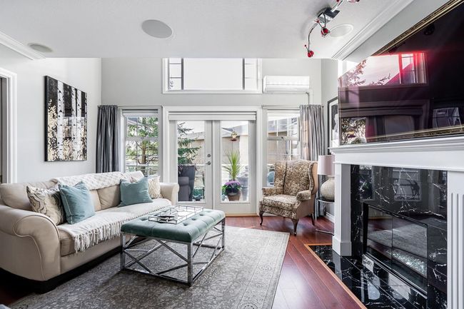 Living room with an AC wall unit and wood finished floors | Image 11