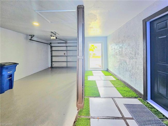 Garage featuring a garage door opener and a textured wall | Image 5