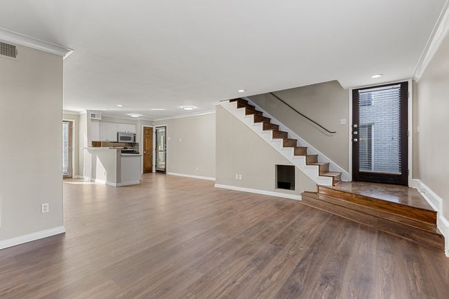 Foyer featuring ornamental molding, baseboards, wood finished floors, and stairs | Image 4