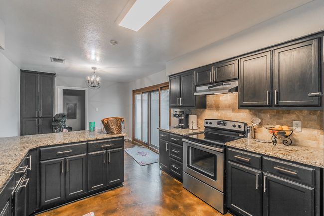 Unit 4904 Kitchen with light stone countertops, stainless steel range with electric cooktop, and decorative backsplash | Image 30