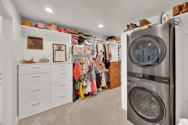 Laundry room with estacked washer and dryer, carpet floors, and recessed lighting | Image 21
