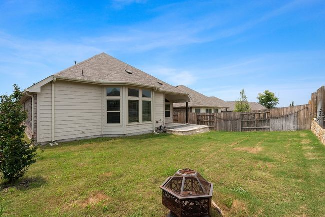 Back of house with a fire pit, a fenced backyard, and a shingled roof | Image 22