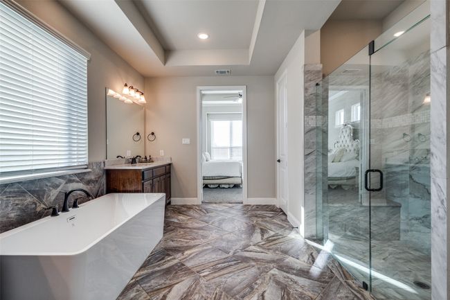 Bathroom featuring vanity, a tray ceiling, and separate shower and tub | Image 19