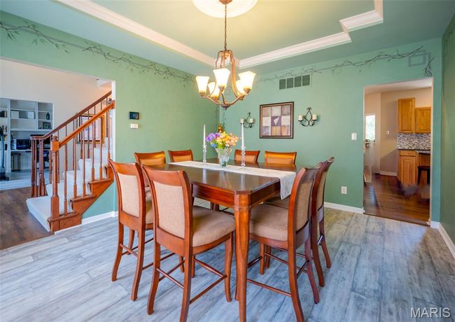 Dining room featuring a chandelier, light wood-type flooring, and stairs | Image 6