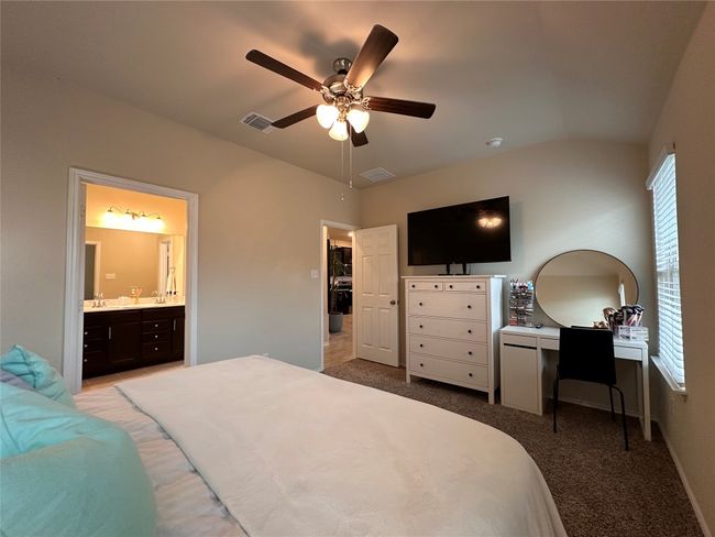 Bedroom with light carpet, a sink, lofted ceiling, ensuite bathroom, and a ceiling fan | Image 31