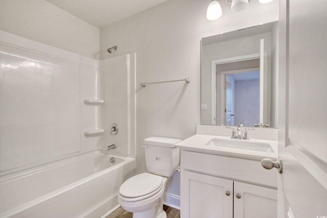 Full bathroom with shower / washtub combination, vanity, wood-type flooring, and toilet | Image 28