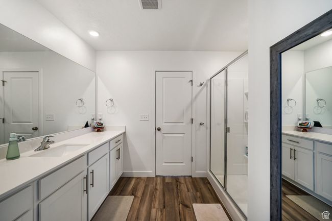Bathroom with vanity, wood finished floors, a shower stall, and baseboards | Image 22
