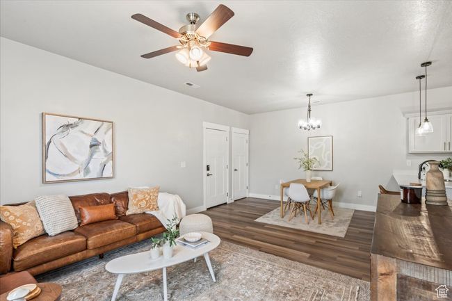 Living room featuring wood finished floors, a chandelier, and ceiling fan | Image 17