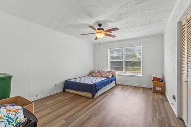 Bedroom with wood finished floors, a textured ceiling, and a ceiling fan | Image 22