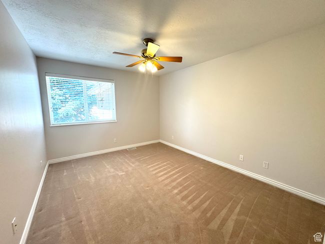 Main level bedroom featuring ceiling fan and large closet with organizer. | Image 17