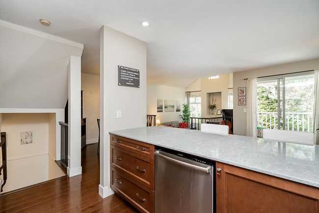 Kitchen with dark wood-style flooring, brown cabinetry, recessed lighting, and stainless steel dishwasher | Image 7