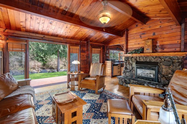 Living room with wood-type flooring, wood ceiling, and wooden walls | Image 5