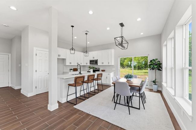 Dinning room overseeing the covered patio and green area. | Image 13