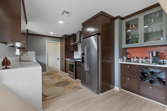 The fully updated kitchen features solid Maple cabinets, plenty of storage and quartz counter tops. | Image 7