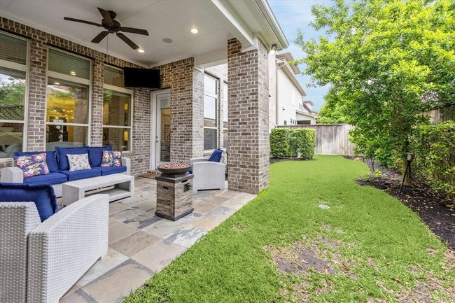 The back patio has a well-maintained lawn and a privacy fence. | Image 34