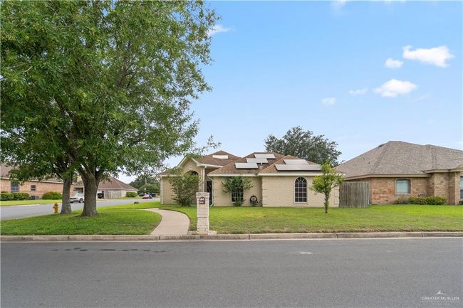 View of front of property featuring roof mounted solar panels and brick siding | Image 24